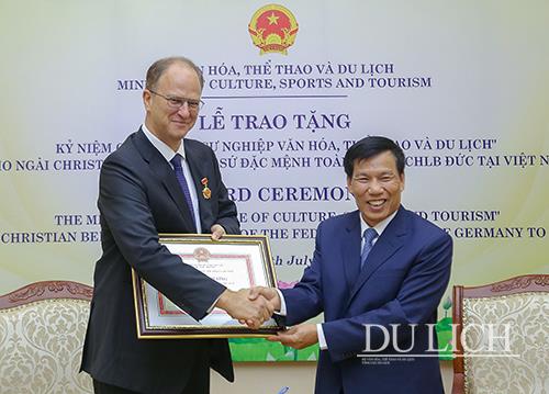 Đại sứ Christian Berger (phải) nhận Kỷ niệm chương từ Bộ trưởng Nguyễn Ngọc Thiện (trái)